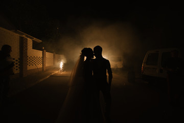 Romantic silhouette of wedding couple with salute