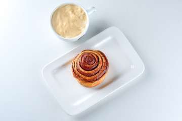Good freshly baked cinnamon bun and a cup of coffee.Top view.