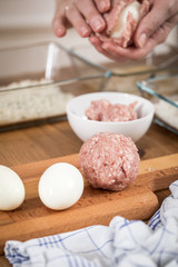 Frau kocht Scotch Eggs, Eier in Schweine Fleisch Wurstbrät und Paniermehl 