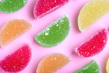 colored jelly slices with sugar crystals, on pink background