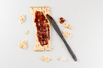 Pesach celebration concept. Matzah and jam on white table, background for Jewish Passover holiday. Jewish Matzah  And Strawberry Preserves for the Passover Seder.