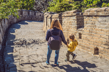 Fototapeta premium Happy cheerful joyful tourists mom and son at Great Wall of China having fun on travel smiling laughing and dancing during vacation trip in Asia. Chinese destination. Travel with children in China