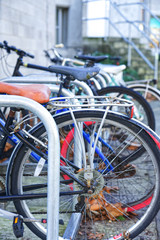 seveeral bicycles secured to metal bike racks in an urban environment 