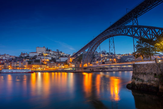 Porto, Portugal. Cityscape image of Porto, Portugal with reflection of the city in the Douro River and the Luis I Bridge during twilight blue hour.