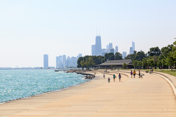 People walking along the shoreline in Chicago, Illinois on a sunny summer morning
