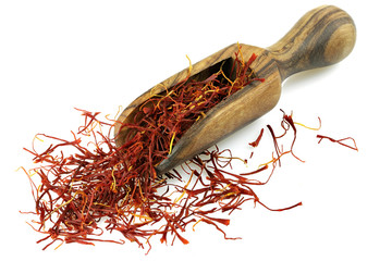 saffron threads in a wooden scoop made of olive wood isolated on white background