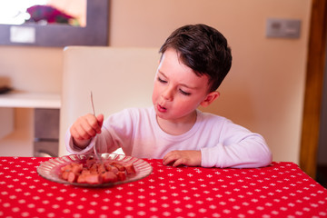  little boy eating sausages