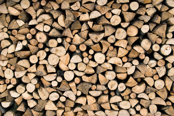 Stacked firewood for the heating season. Firewood stack wall. Wood texture background.