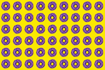 Sweet and tasty donuts with purple and pink glazing as a pattern on bright yellow background. Home made dessert and baking concept.