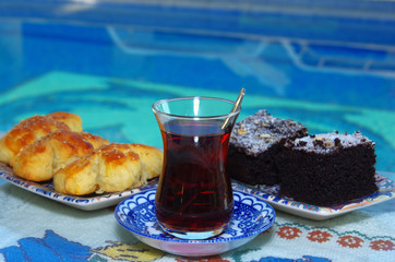 Turkish pastry, chocolate cake and tea by poolside