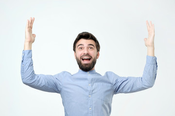 Happy young bearded man bragging about the big size of something