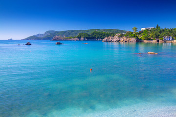 Naklejka na ściany i meble Beautiful summer panoramic seascape. View of the cliff into the sea bay with crystal clear azure water in sunshine daylight. Boats and yachts in the harbor. Mediterranean sea, somewhere in Europe.