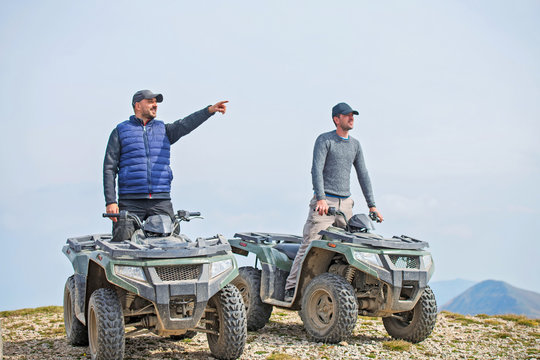 male riend riding atv vehicle on off road track enjoying view.
