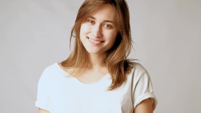 Young playful atractive woman striking poses, flirting romanticly and sending kisses on camera