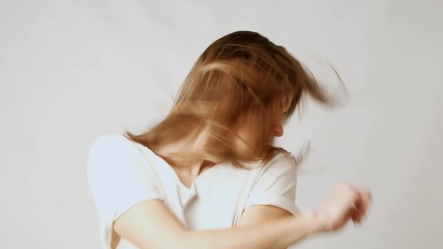 Young playful attractive woman dancing and playing with hair infront of camera