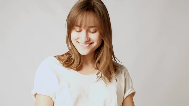 Young playful atractive woman striking poses, flirting, smiling, playing with hair on camera
