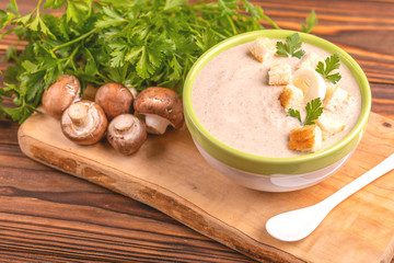Tasty pureed mushroom soup in clay bowl with ingredients