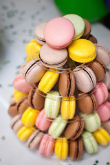 colorful french macarons multilevel cake pyramid on plastic dessert stand.