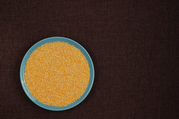 Corn grits polenta in a blue plate on linen background