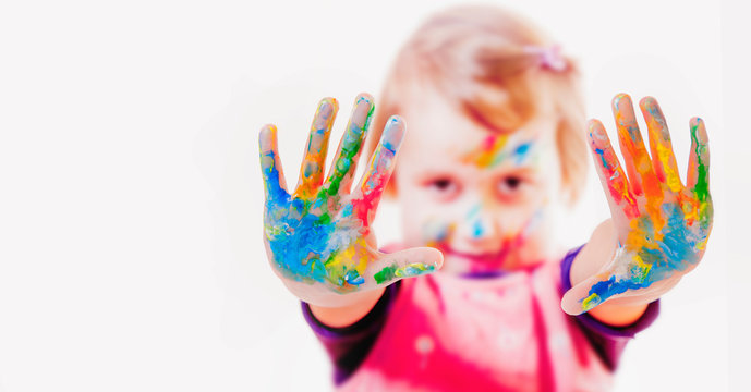 Little cute child girl showing painted hands. Education, school, art and painting concept.