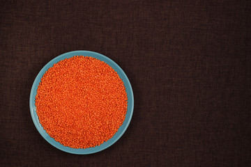 Healthy Food concept red lentils in blue ceramic plate on linen background with copy space