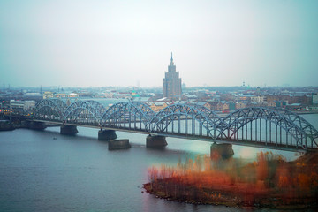 Fototapeta na wymiar Railway bridge with the city of Riga as background