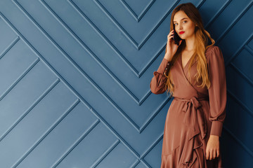 Fototapeta premium attractive stylish young girl with phone on simple aqua background