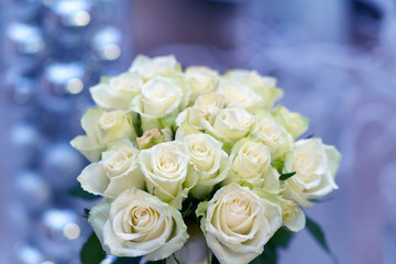Round posy of fresh white roses over blue