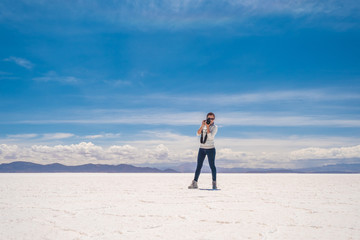 Obraz premium Girl taking photo in sunshine Salar de Uyuni