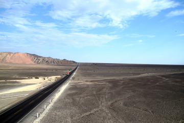 Road leading the way towards new destinations and adventures. Black empty road in the desert. Photo taken nearby Nazca, Peru