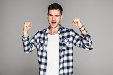 Naklejka premium Happy winner. Happy young handsome man gesturing and keeping mouth open while standing against white background