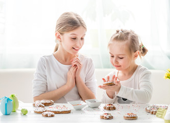 Obraz na płótnie Canvas Girls decorating homemade gingerbread cookies