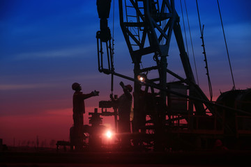 Oil workers work in the evening at the oil field