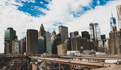Manhattan skyline seen from the beautiful Brooklyn bridge. Cloudy day in New York City, USA.