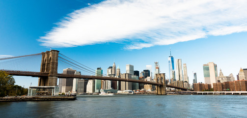 Fototapeta premium Manhattan skyline with the Brooklyn bridge and the One World Trade Center in the background during a sunny day in New York, USA.