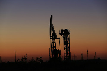 The pumping unit is at work in the evening of the oilfield