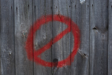 No Stopping sign drawn on wooden wall, fence. Grounge wooden background with STOP sign, red spray.