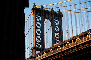 Close-up view of the Manhattan bridge seen from a narrow alley during the sunset. Manhattan, New York City, USA.