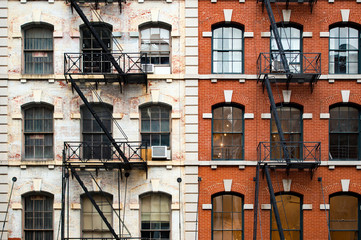 Close-up view of New York City style apartment buildings with emergency stairs along Mott Street in Chinatown neighborhood of Manhattan, New York, United States.. - obrazy, fototapety, plakaty
