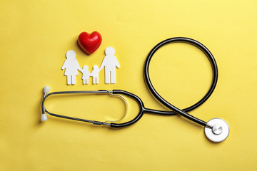 Flat lay composition with heart, stethoscope and paper silhouette of family on color background....