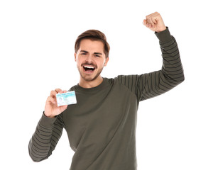 Happy young man with driving license on white background