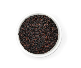 Fototapeta na wymiar Bowl with uncooked black rice on white background, top view
