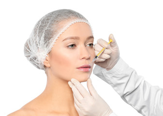 Young woman getting lips injection on white background. Cosmetic surgery