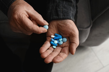 Senior man taking pills, closeup of hands