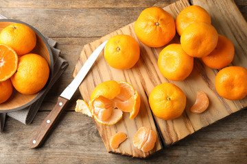 Flat lay composition with ripe tangerines on wooden background