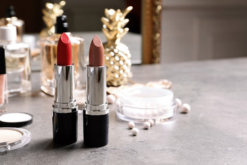 Bright lipsticks on dressing table. Space for text