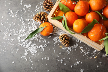 Christmas composition with ripe tangerines, artificial snow and space for text on grey background, top view