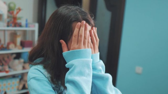 peek a boo. little girl covered her eyes face with her hands hide-and-seek waiting for a surprise. slow motion video lifestyle . teen girl playing bo-peep. childhood concept game hy - spy
