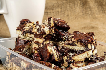 Chocolate brownies with coffee on a rug background.