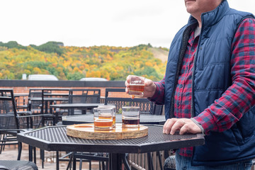 Man tasting craft beer at an outdoor beer garden in fall